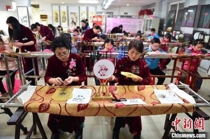 江西省級非遺豫章繡傳承人手把手指導小學生繡制2022年北京冬奧會吉祥物“冰墩墩”形象?！∮髟屏?攝