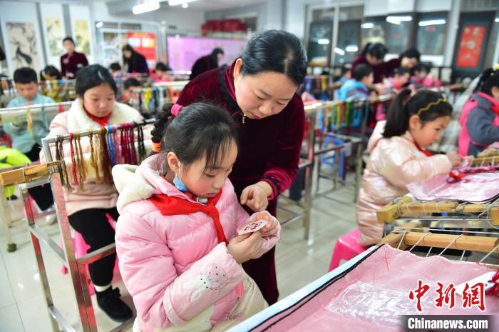 江西省級非遺豫章繡傳承人手把手指導小學生繡制2022年北京冬奧會吉祥物“冰墩墩”形象?！∮髟屏?攝