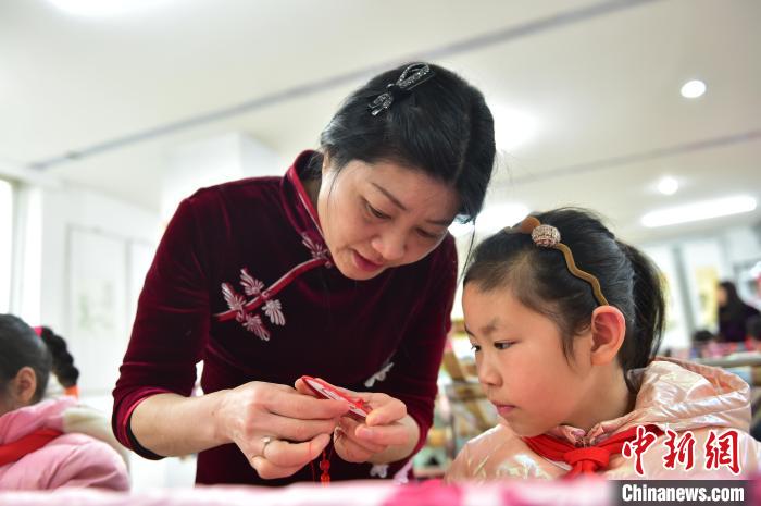 江西省級非遺豫章繡傳承人手把手指導小學生繡制2022年北京冬奧會吉祥物“冰墩墩”形象?！∮髟屏?攝