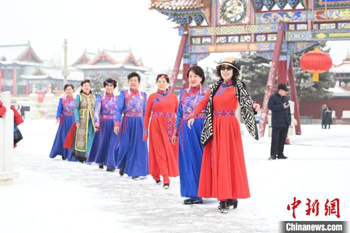 2月13日，老年人在呼和浩特市大召?gòu)V場(chǎng)拍照“打卡”?！⑽娜A 攝