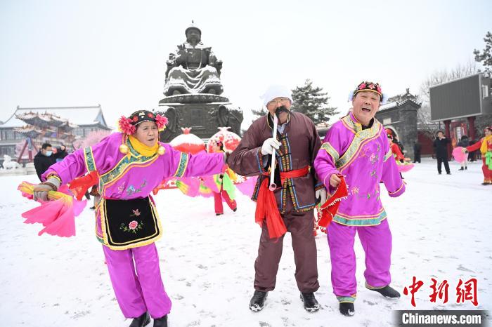 2月13日，秧歌隊(duì)在呼和浩特市大召?gòu)V場(chǎng)雪中起舞?！⑽娜A 攝
