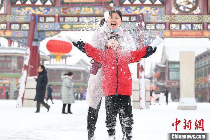 2月13日，家長(zhǎng)與小朋友在呼和浩特市大召?gòu)V場(chǎng)享雪趣。　劉文華 攝