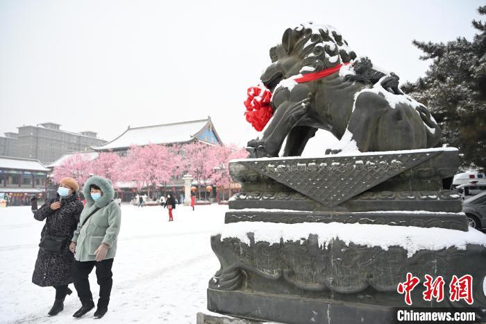2月13日，民眾在呼和浩特市大召?gòu)V場(chǎng)雪中漫步。　劉文華 攝