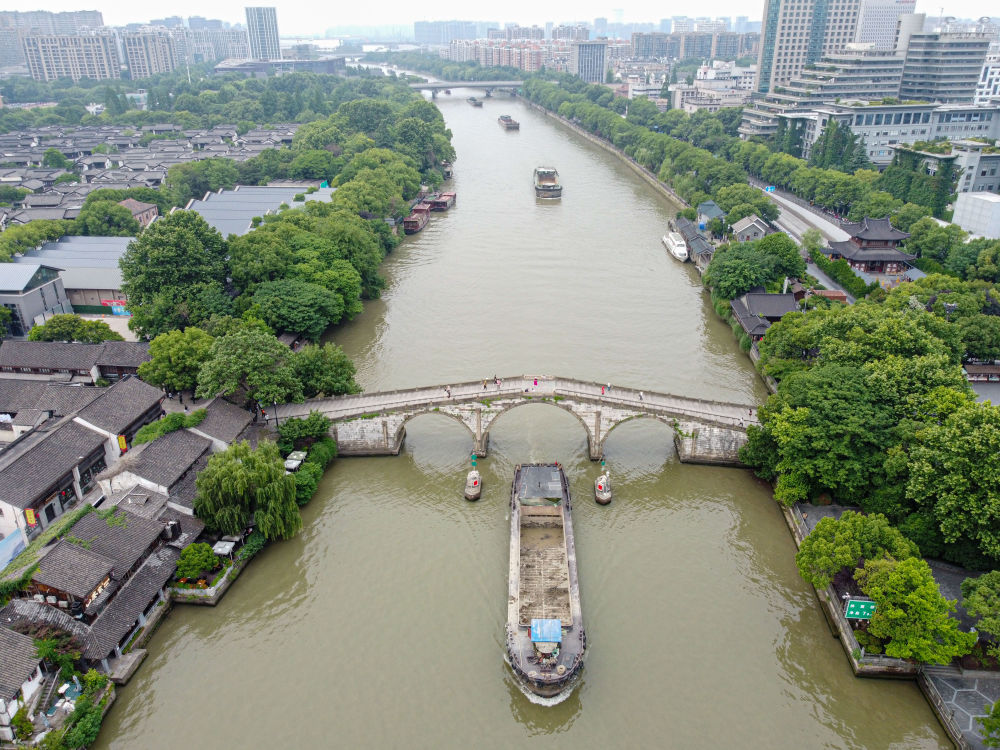 5月27日，一艘貨船駛過京杭大運河南端標志建筑杭州拱宸橋。(無人機照片)新華社記者江漢 攝