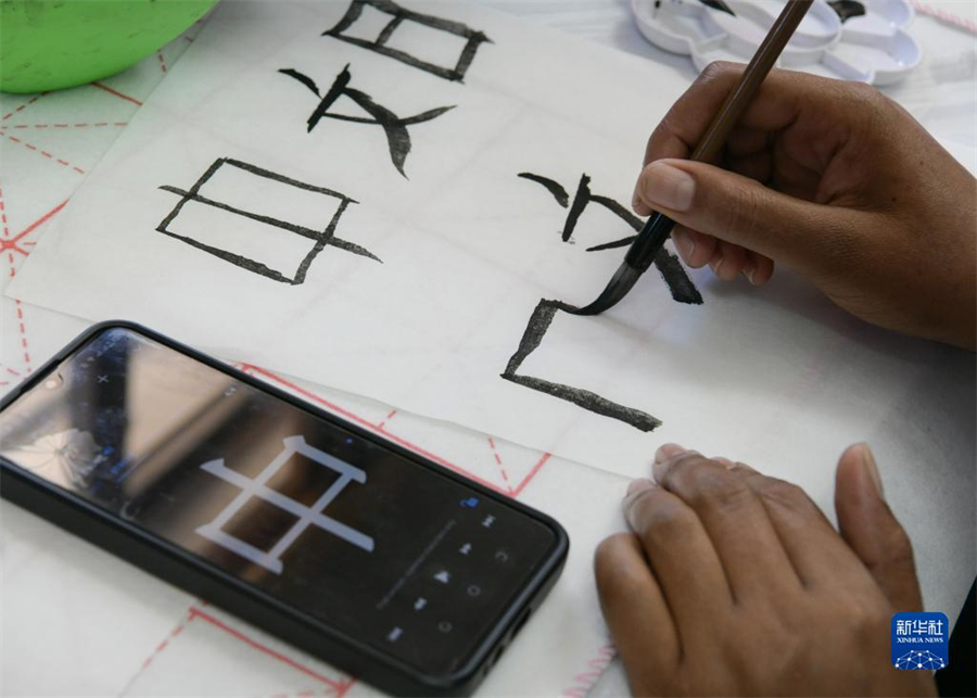 4月18日，肯尼亞學(xué)生在內(nèi)羅畢大學(xué)孔子學(xué)院舉辦的活動(dòng)上寫(xiě)毛筆字?？夏醽唭?nèi)羅畢大學(xué)孔子學(xué)院18日舉辦“中文，增進(jìn)文明對(duì)話”主題活動(dòng)，慶祝即將到來(lái)的第14個(gè)聯(lián)合國(guó)中文日?？夏醽唽W(xué)生參與互動(dòng)，進(jìn)行書(shū)法、剪紙、唱中文歌等活動(dòng)。新華社記者 韓旭 攝