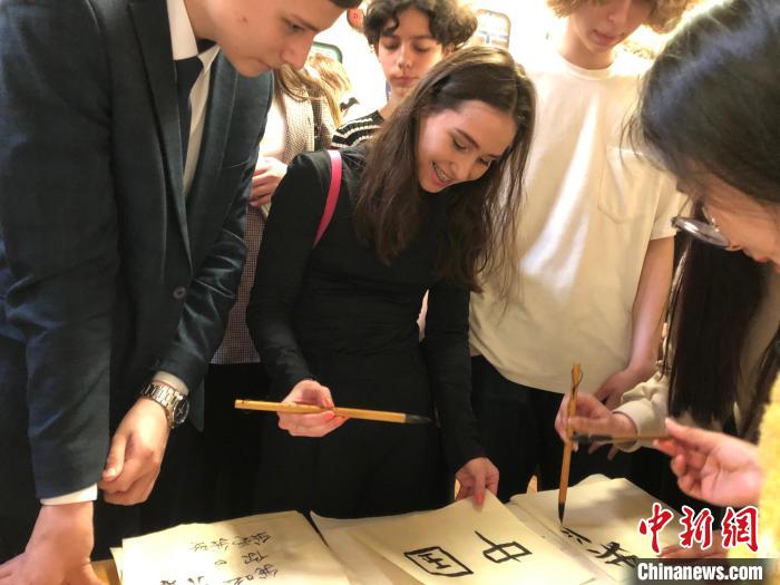 4月21日，莫斯科國(guó)立語(yǔ)言大學(xué)孔子學(xué)院附屬中學(xué)舉辦“國(guó)際中文日”活動(dòng)，學(xué)生們學(xué)寫漢字?！∧箍茋?guó)立語(yǔ)言大學(xué)孔子學(xué)院 供圖