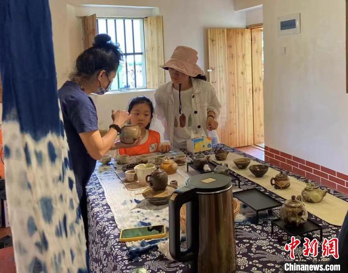 圖為：游客正在咨詢臺灣柴燒作品?！∪~秋云 攝