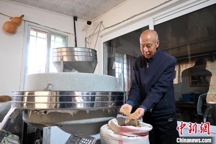 李家莊村民谷文朝重拾父輩的手藝，做起石磨面粉的營生?！〉杂鸺?攝