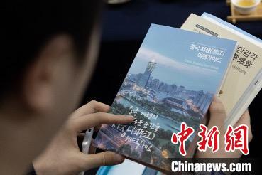 參展觀眾閱讀浙江文旅手冊?！《≌裾?攝