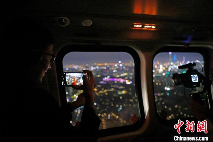 6月3日晚，游客乘坐上海新空直升機有限公司直升機開啟鳥瞰黃浦江空中圓夢之旅，并用手機拍攝城市夜景?！∫罅⑶?攝
