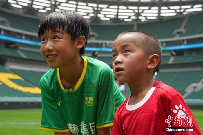 圖為北京國(guó)安小球員陳小北和7歲的俄金仁增在一起觀看場(chǎng)內(nèi)播放的紀(jì)錄片。<a target='_blank' href='/' _fcksavedurl='/'><p  align=
