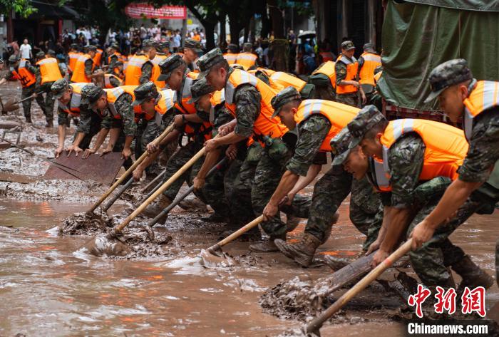 7月4日，萬州區(qū)五橋街道，武警官兵清理街道上的淤泥。　冉孟軍 攝