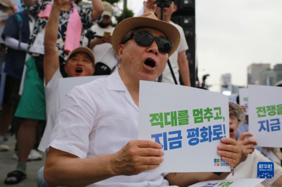 7月22日，在韓國首爾，人們手舉標(biāo)語參與反戰(zhàn)游行。新華社發(fā)（楊暢 攝）