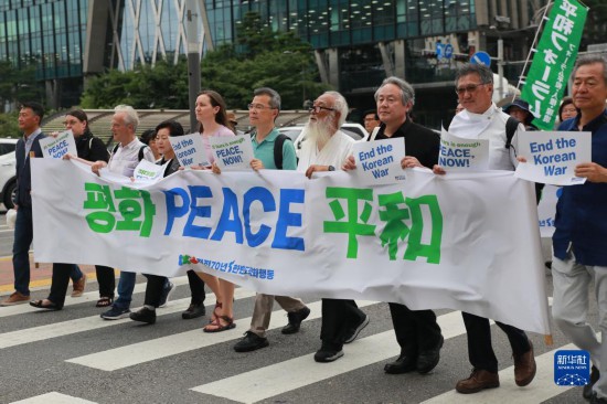 7月22日，在韓國首爾，人們手舉標(biāo)語參與反戰(zhàn)游行。新華社發(fā)（楊暢 攝）