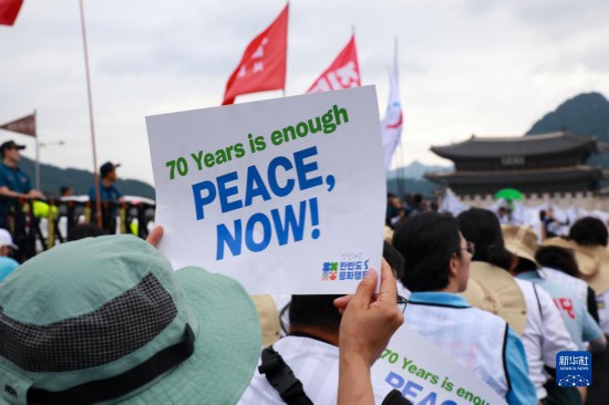 7月22日，在韓國首爾，人們手舉標(biāo)語參與反戰(zhàn)游行。新華社發(fā)（楊暢 攝）