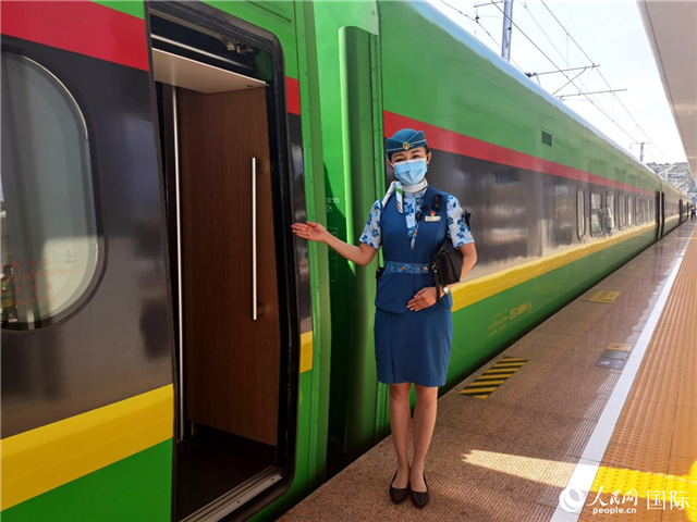 趙瑩靜站在“復(fù)興號(hào)”國(guó)際旅客列車車廂門口歡迎旅客上車。人民網(wǎng) 杜明明攝