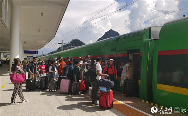 乘坐中老鐵路國(guó)際旅客列車的旅客在老撾瑯勃拉邦站排隊(duì)上車。人民網(wǎng)記者 杜明明攝