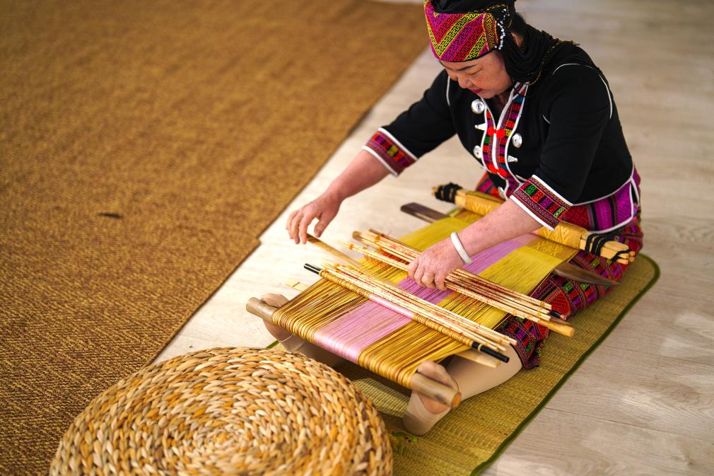 4月17日，黎族傳統(tǒng)紡染織繡技藝國(guó)家級(jí)代表性傳承人劉香蘭在2023年意大利米蘭設(shè)計(jì)周上展示黎錦織造技藝。新華社發(fā)