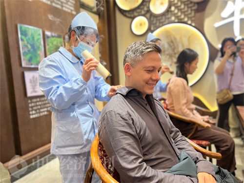   （外媒記者體驗艾灸。中國經(jīng)濟周刊記者 郭志強 攝）