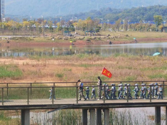 　　10月24日，秋游的幼兒園小朋友在老師帶領(lǐng)下走在清水塘公園里的木橋上。本報(bào)記者 常雯宜攝
