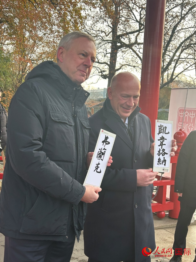 柏林市長(zhǎng)韋格納（右）、動(dòng)物園監(jiān)事會(huì)主席布魯克曼（左）手持中國(guó)文化中心工作人員現(xiàn)場(chǎng)手書(shū)的中文名字。人民網(wǎng)記者 徐馨攝