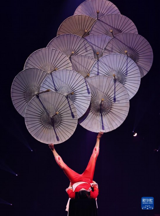 12月8日，演員在法國(guó)巴黎舉行的中國(guó)雜技“奇妙之夜”演出上表演《蹬傘》。新華社記者 高靜 攝