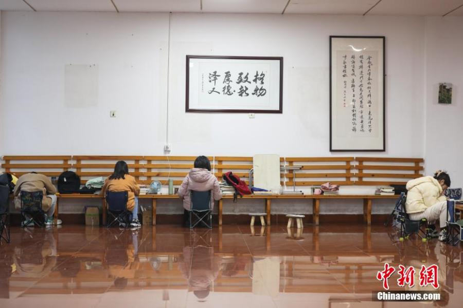 資料圖：幾位考研學(xué)生在南昌大學(xué)教學(xué)樓的公共空間復(fù)習(xí)備考。劉力鑫 攝