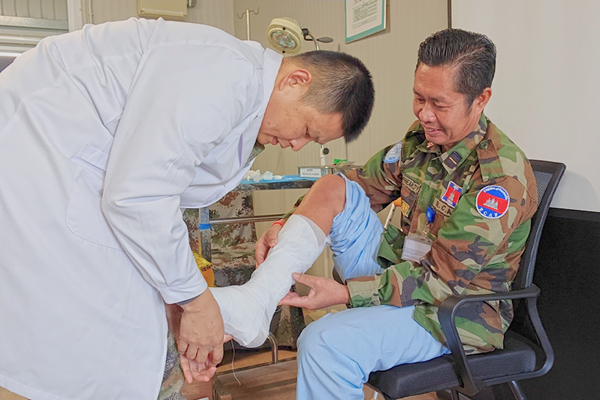 中國第22批赴黎維和醫(yī)療分隊軍醫(yī)為患者打石膏固定患肢。李清竹攝