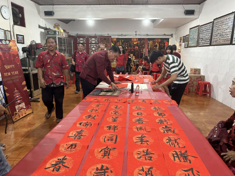 茍皓東為華人朋友現(xiàn)場寫春聯(lián)送福字。巴陵康孔子學(xué)院供圖