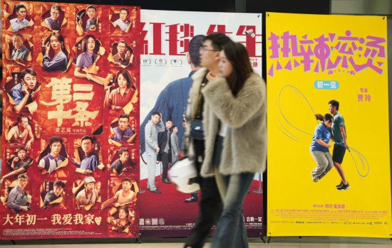 這是2月17日，在沈陽一家影院，觀眾從海報前經(jīng)過。新華社記者李鋼攝