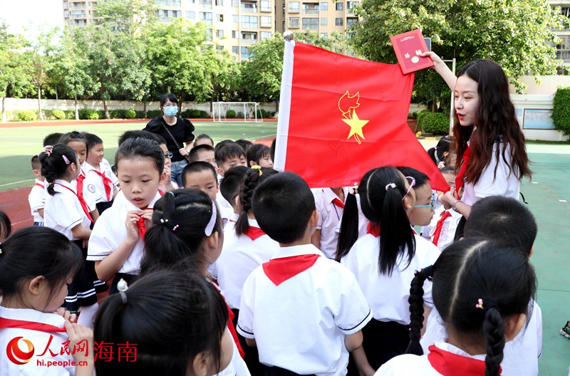 老師向少先隊(duì)員展示隊(duì)旗。人民網(wǎng) 符武平攝