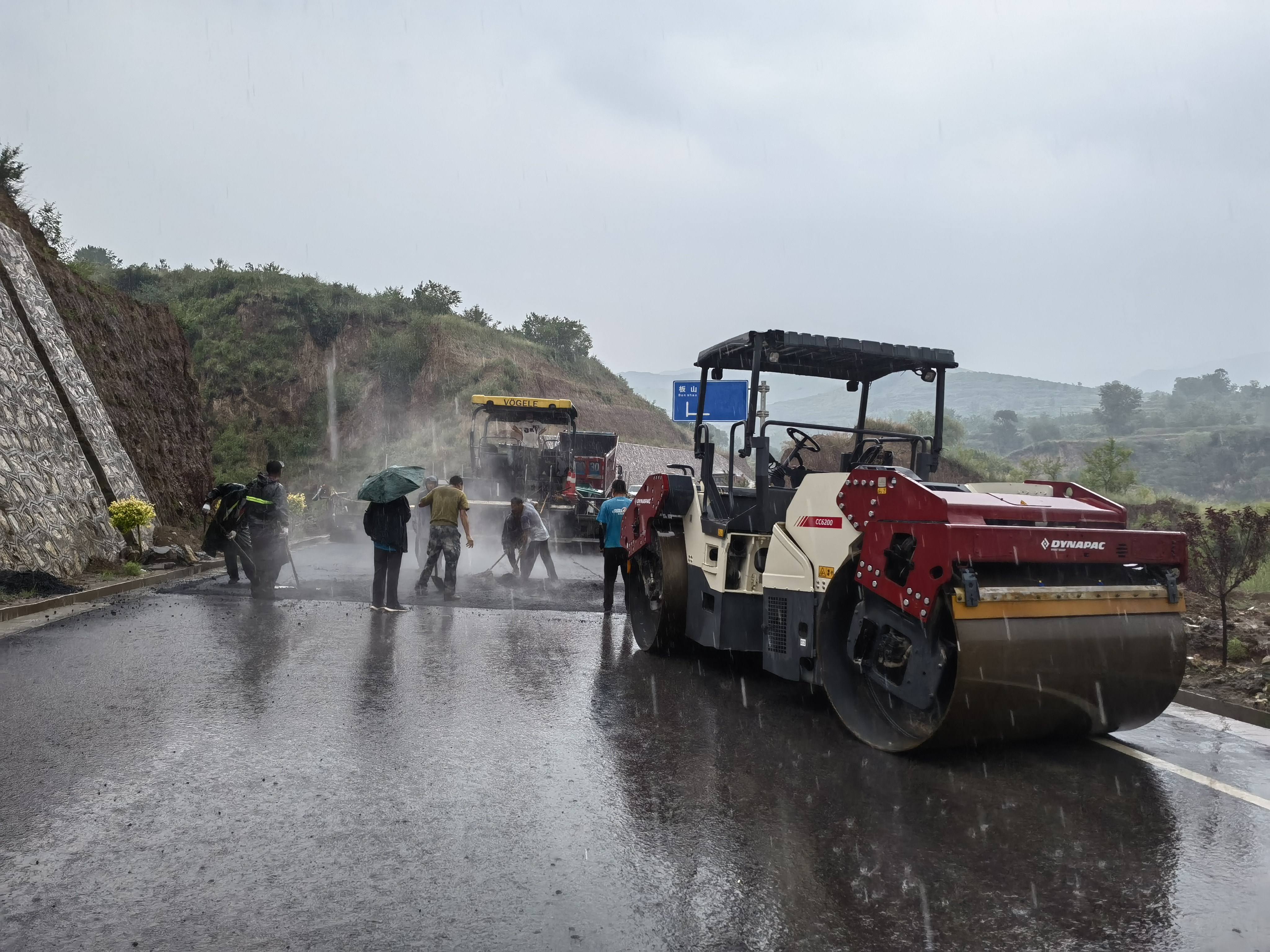 路橋工人在大雨中搶修道路。李華英 攝