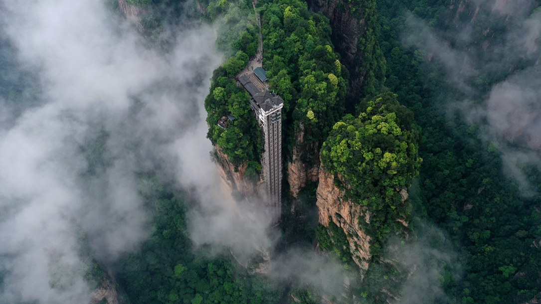 位于張家界武陵源景區(qū)的百龍?zhí)焯蓁偳对谠旗F繚繞的峰林間，雄偉壯觀。吳勇兵攝