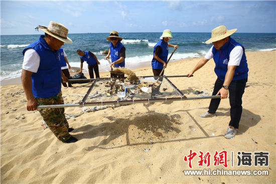 環(huán)保志愿者用篩網(wǎng)“淘”出海灘上的垃圾。