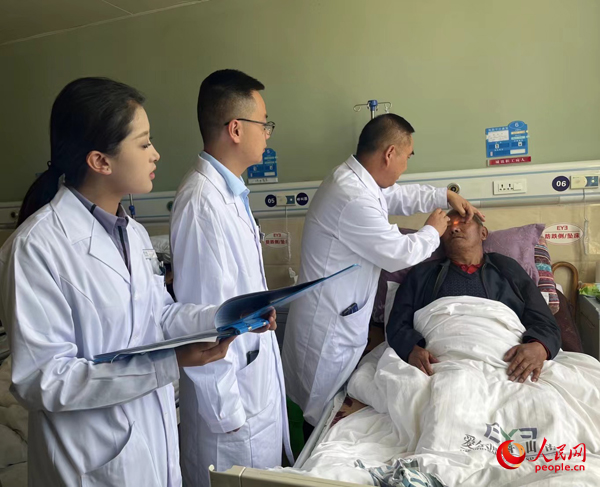 董光明（左三）帶領醫(yī)生對患者進行術前檢查。人民網記者 杜燕飛攝
