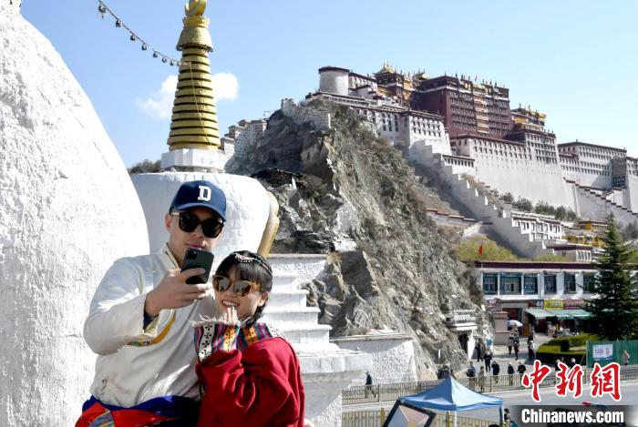 4月17日，游客身著藏式元素服裝在拉薩布達(dá)拉宮觀景臺(tái)拍照留念?！±盍?攝