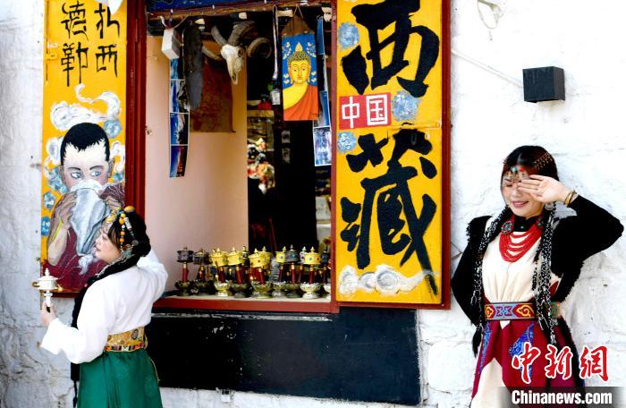 4月17日，游客身著藏式元素服裝在拉薩八廓街拍照留念?！±盍?攝