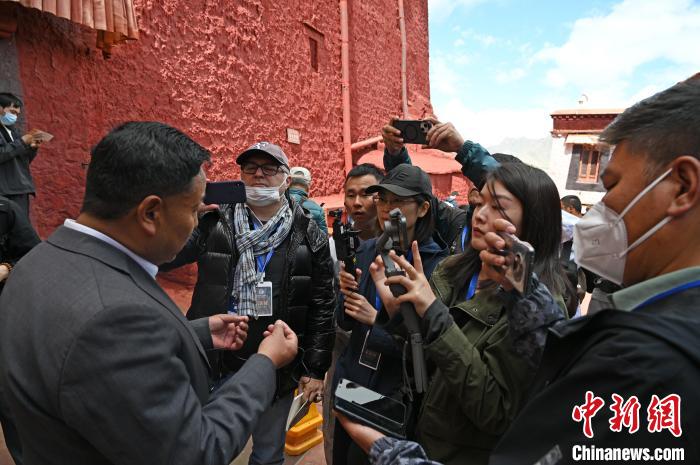 圖為中外媒體采訪布達拉宮管理處相關(guān)負責人?！≮w朗 攝