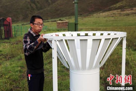 圖為班瑪縣氣象局工作人員在維護藏雪茶基地氣候站。青海省氣象局供圖