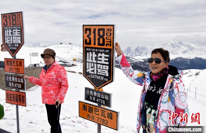 圖為5月14日，西藏林芝色季拉山觀景臺，游客與南迦巴瓦峰合影?！±盍?攝