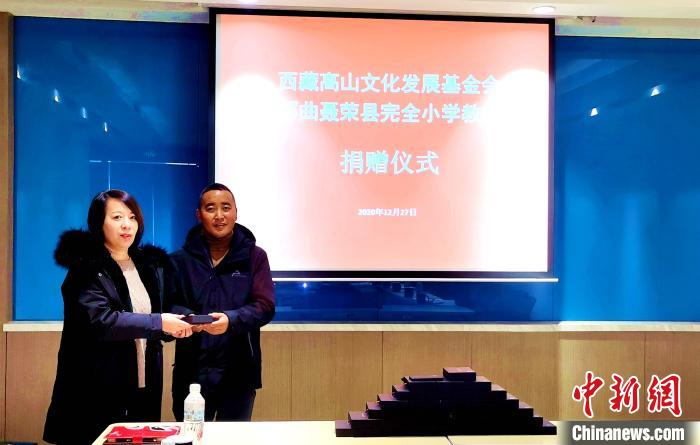 圖為西藏高山文化發(fā)展基金會理事長溫麗向聶榮縣完全小學負責人捐助儀器。　于賓 攝