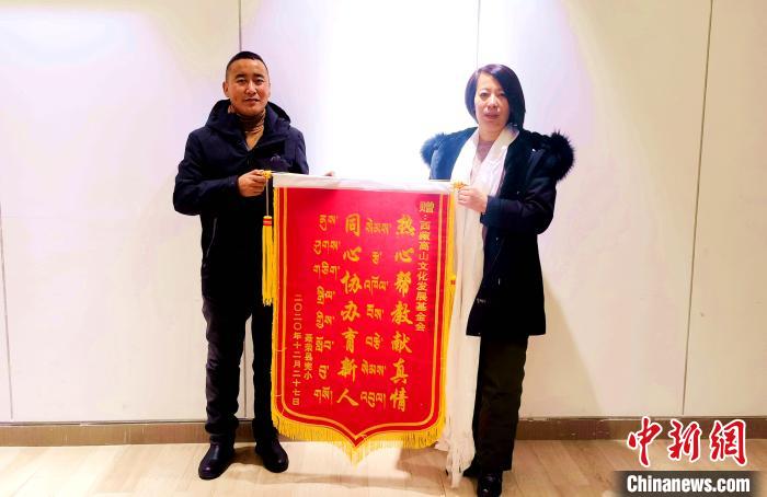 圖為聶榮縣完全小學向西藏高山文化發(fā)展基金會贈送錦旗。　于賓 攝