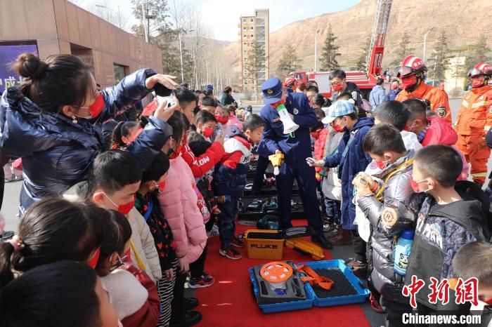 圖為小朋友們聽消防員講解消防器材?！铨埥?攝