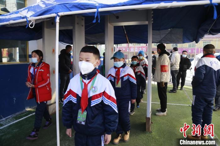 圖為學生測量體溫后進入校園?！●R銘言 攝