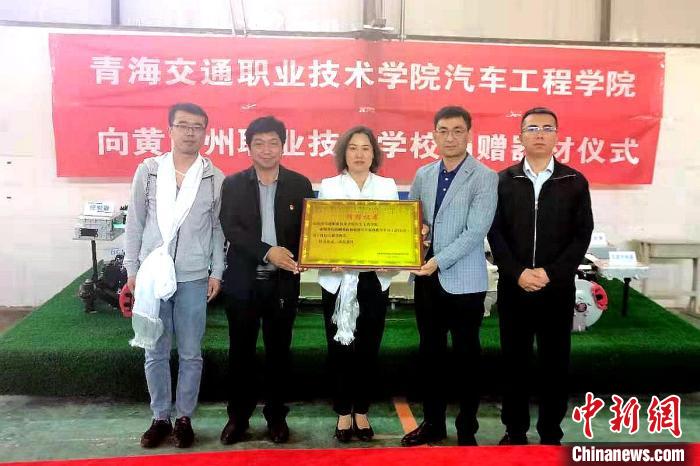 圖為李富香(中)代表學(xué)校為州縣技校捐贈(zèng)器材。(資料圖) 青海省教育廳供圖