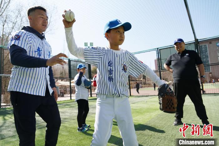 圖為教練指導(dǎo)小棒球手?jǐn)S球技術(shù)?！●R銘言 攝