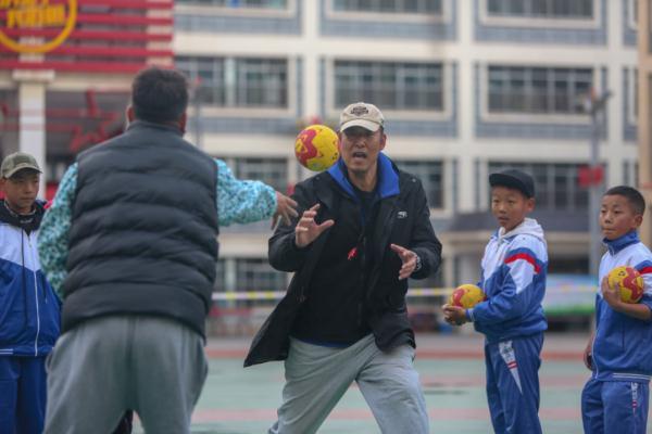 在高原上教孩子們打手球，“慢慢兒來，甭著急！”
