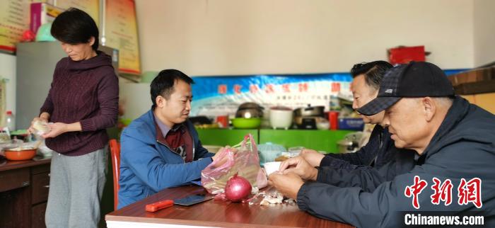 圖為扶貧路上“臨時一家人”準(zhǔn)備午餐?！∥航ㄜ?攝