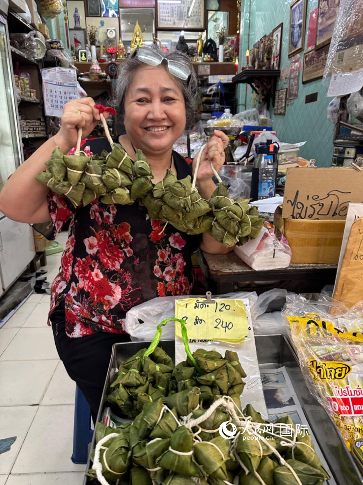 商家向顧客介紹“吉掌”（粽子的一種，一串一串，個(gè)頭較?。Ｈ嗣窬W(wǎng)記者 簡(jiǎn)承淵攝