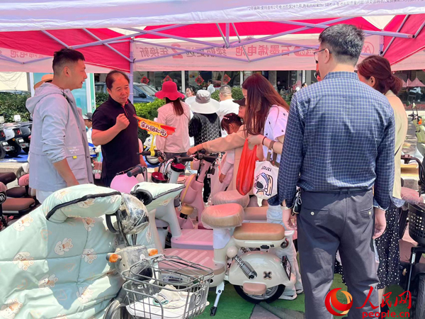 某電動自行車品牌工作人員向消費者介紹以舊換新相關情況。人民網(wǎng)記者 杜燕飛攝